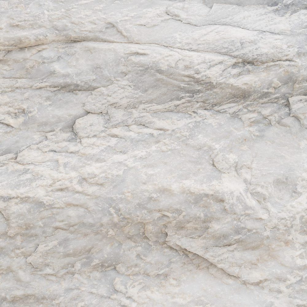 The grain of a pale ivory marble surface